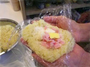 ラップを利用して手のひらにお米をのせます。